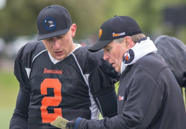 A coach and player talking on the field