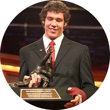 A man in a suit holding a trophy.